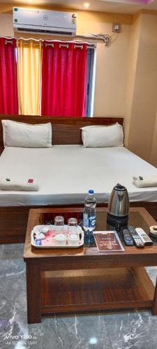 a room with a bed and a table with a coffee table sidx sidx at Hotel Tulusi Inn ! Bolpur, Shantiniketan ! Luxury Feel In Budget in Bolpur