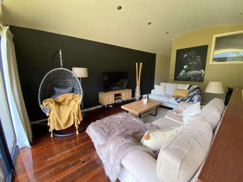 a living room with a white couch and a table at Halls Gap Escape Townhouses in Halls Gap