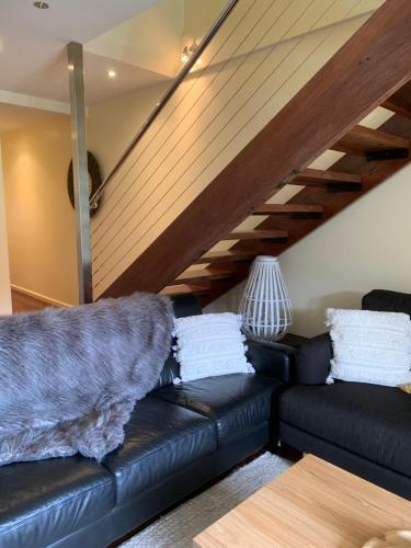 a black leather couch in a living room at Halls Gap Escape Townhouses in Halls Gap