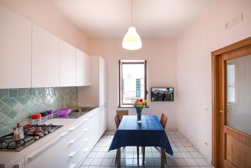 a kitchen with a table with a vase of flowers on it at Ravello House in Ravello