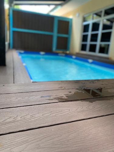 an empty swimming pool with a wooden deck at Casa D' Bernam in TanjongMalim