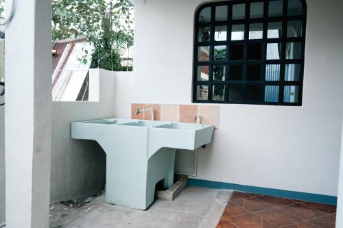 a bathroom with a white sink and a mirror at Hostal Casa Ale in San Juan La Laguna