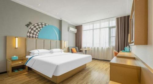 a bedroom with a large white bed in a room at City Comfort Inn Dangtu High Speed East Railway Station RT-Mart in Ma'anshan