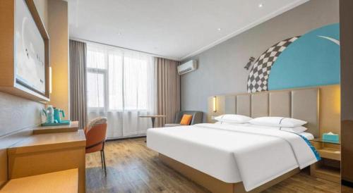 a bedroom with a large white bed and a desk at City Comfort Inn Dangtu High Speed East Railway Station RT-Mart in Ma'anshan