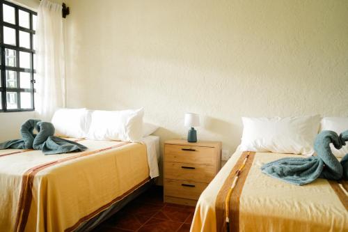 two beds in a room with swans on them at Hostal Casa Ale in San Juan La Laguna