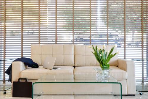 a living room with a couch and a laptop on a table at Athens Avenue Hotel in Athens