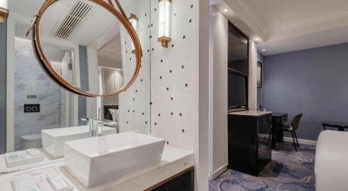 a bathroom with a sink and a mirror at Jinjiang Metropolo Hotel Nanjing Confucius Temple Branch in Nanjing