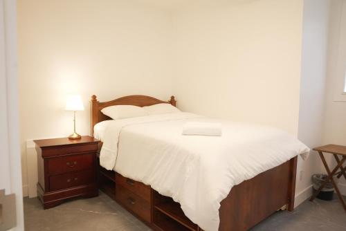 a bedroom with a bed with white sheets and a lamp at 5003R New Luxury Walkout Suite Near Calgary University in Calgary