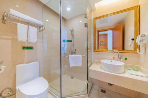 a bathroom with a shower and a toilet and a sink at Out Sky Hotel in Huizhou