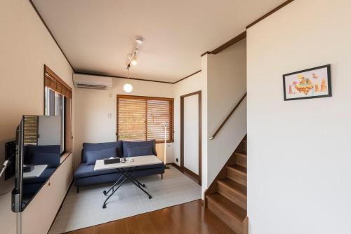 a living room with a blue couch and a table at シーサイド興津 in Sanuki