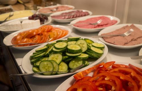 a table topped with plates of vegetables and meats at Sundsvall City Hotel in Sundsvall