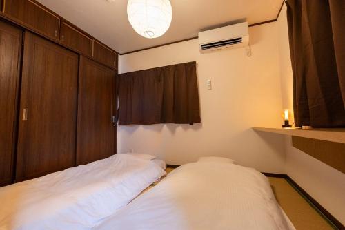 two beds in a small room with a window at シーサイド興津 in Sanuki