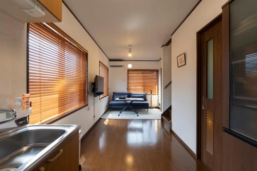 a kitchen with a sink and a couch in a room at シーサイド興津 in Sanuki