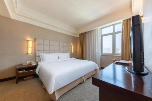 a hotel room with a bed and a television at Best Western Plus Fuzhou Fortune Hotel in Fuzhou