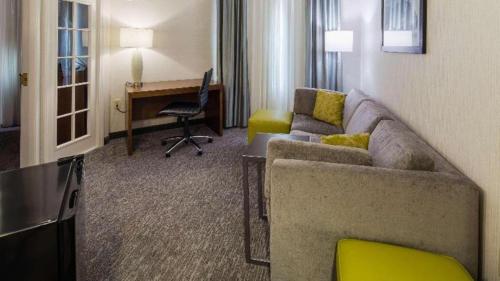 a living room with a couch and a desk in a hotel room at Best Western Plus Boston Hotel in Boston