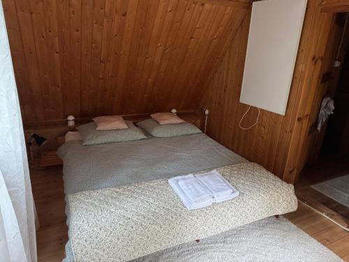 two twin beds in a room with wooden walls at Leśna Chata Arciechów in Arciechow