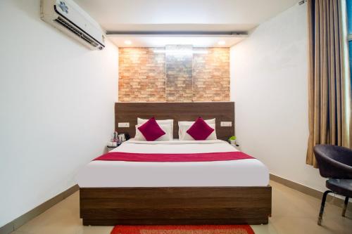 a bedroom with a large bed with red pillows at HOTEL S R Palace - Free Airport Drop for Minimum 05 Nights Stay - 5 mins from IGI & Domestic Airport Delhi in New Delhi