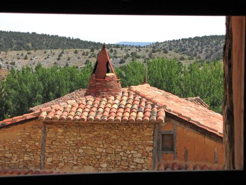an old stone building with a roof with a triangle at Hotel Rural Calatañazor in Calatañazor