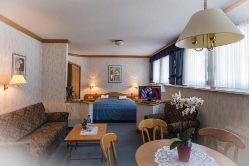 a hotel room with a couch and a bed at Gasthof Rodachtal mit Gästehaus Katharina in Schwarzenbach am Wald