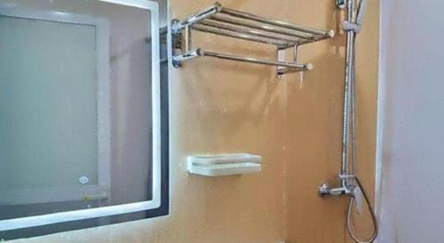 a shower in a bathroom with a mirror at GreenTree Inn Kunming Baiyun Road Tongde Plaza Branch in Kunming