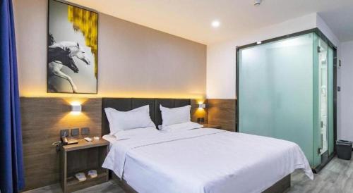 a bedroom with a large white bed in a room at 7 Days Inn Tianjin Development Zone 3rd Street Wanli in Binhai