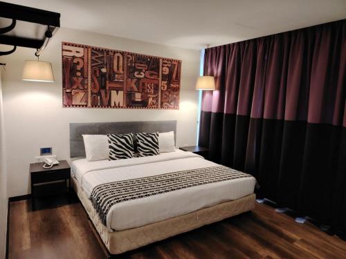 a bedroom with a bed and a painting on the wall at 9 Square Hotel - Subang in Subang Jaya