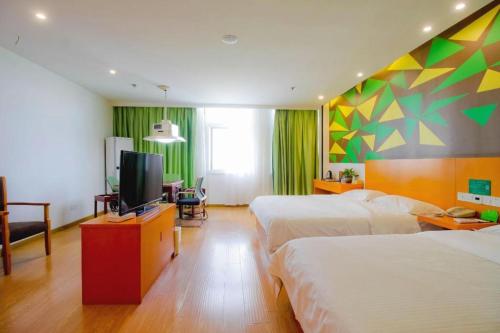 a hotel room with two beds and a flat screen tv at Vatica Anhui Hefei South High Speed Rail Station Susong Road Hotel in Hefei