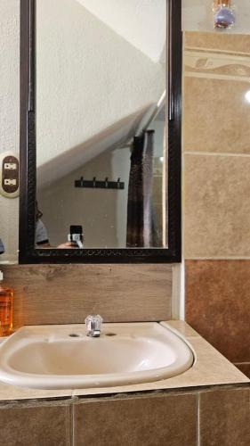 a sink in a bathroom with a mirror at Hostal Casa Ale in San Juan La Laguna