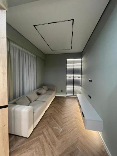 een woonkamer met een witte bank en een raam bij 13 mountains in Bisjkek