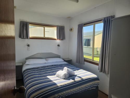 a bedroom with a bed with a towel on it at Eden Gateway Holiday Park in Eden
