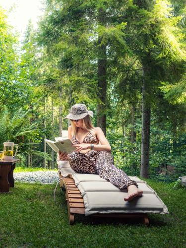 a woman sitting on a mattress with a laptop at Chalet Látky in Látky