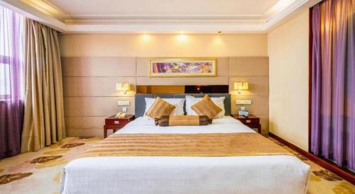a hotel room with a large bed with pillows at Xian Union Alliance Atravis Executive Hotel in Xi'an