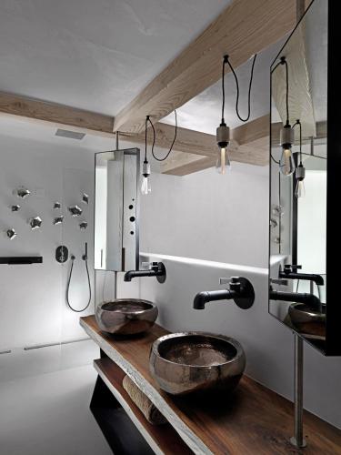 a bathroom with two sinks on a wooden counter at Kove Mykonos - A Myconian Collection Hotel in Ornos
