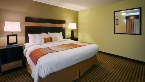 a hotel room with a large bed and a mirror at Best Western Rama Inn in Ephrata