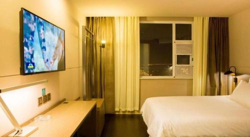 a hotel room with a bed and a television at Jinjiang Inn Select Kunming High-speed South Railway University Town in Kunming