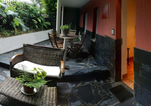 un patio avec deux chaises et une table avec des plantes en pot dans l'établissement Apartamentos Los Balcones, à Tineo