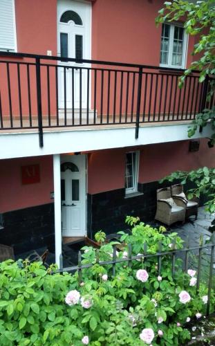 a building with a balcony with a bench and flowers at Apartamentos Los Balcones in Tineo