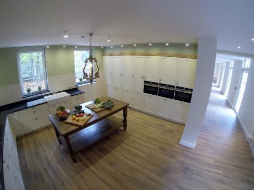 a large kitchen with white cabinets and a table at Luxurious Mettet Mansion in Mettet