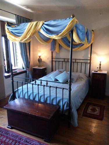 a bedroom with a bed with a canopy at Archontiko Pantou in Portariá