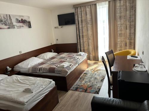 a hotel room with two beds and a desk at Penzion PKO Nitra in Nitra
