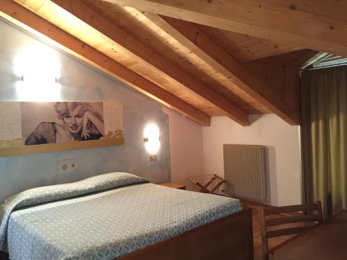 a bedroom with a bed and a picture on the wall at Hotel da Rita in Condino