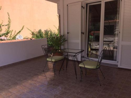 a patio with two chairs and a table on a porch at Waterside Apartments in Ayia Evfimia