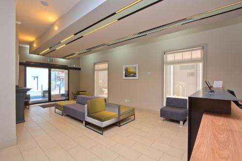 a waiting room with couches and chairs and a desk at The Park Lodge Hotel in Pretoria