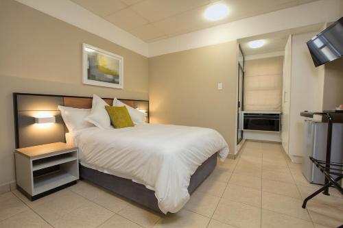 a bedroom with a large bed and a television at The Park Lodge Hotel in Pretoria
