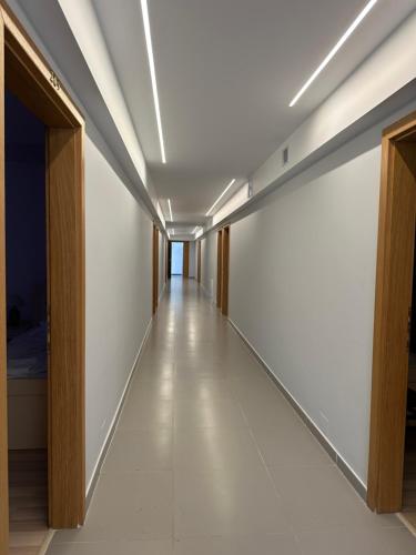 a long hallway with white walls and a ceiling at Bar Restorant Hotel Real in Kolgecaj
