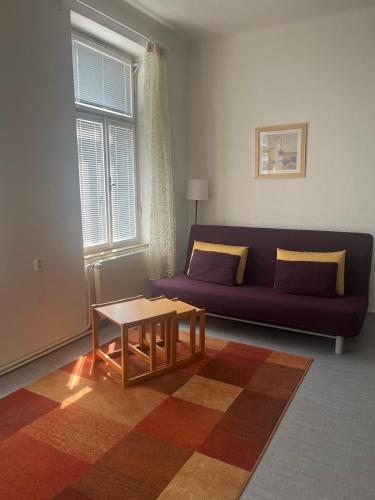 a living room with a purple couch and a table at Na Mahlerce in Jihlava