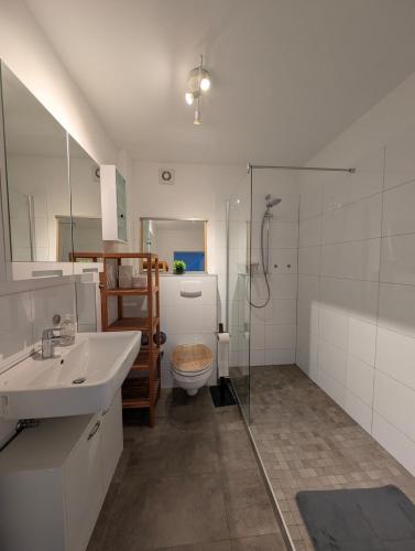 a bathroom with a toilet and a sink and a shower at Traumwohnung über den Dächern Rüttenscheids in Essen