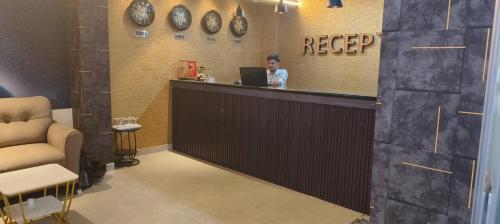 a woman sitting at a counter with a laptop at HoTEL MOON LIGHT in Vijayawāda