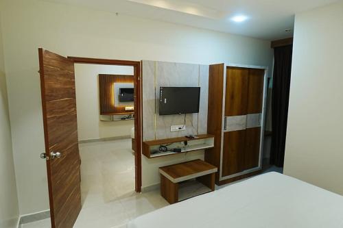 a hotel room with a bed and a television at HoTEL MOON LIGHT in Vijayawāda