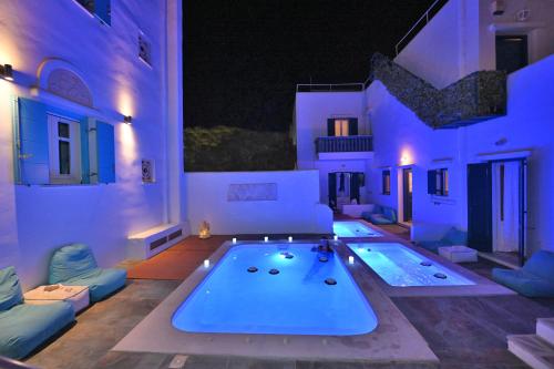 a large swimming pool in a living room with purple lighting at TINOS AQUA PALAZZO in Tinos Town